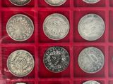 a red box with a lot of silver coins in it