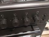 a black stove top with four burners on it