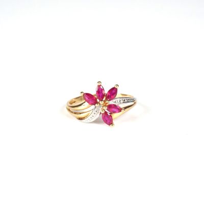 a close up of a gold ring with a pink flower on it