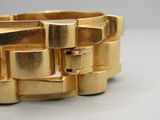 gros plan d'un bracelet en or sur une table