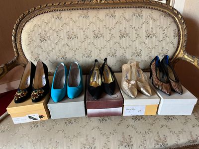 several pairs of women ' s shoes are lined up on a chair