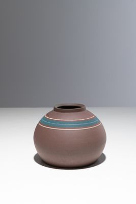 un petit vase marron orné d'une bande bleue