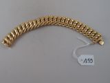 a close up of a gold bracelet on a white surface