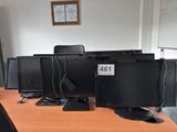 three computer monitors sitting on a desk in an office