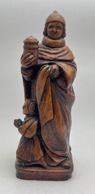 wooden figurine of a monk holding a bottle of wine