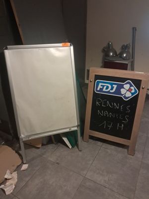 un tableau noir à côté d'un autre tableau noir posé par terre