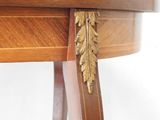 a wooden table with a gold leaf decoration on top of it