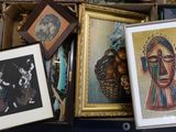 une boîte remplie d'œuvres d'art encadrées et de photos posée sur une table