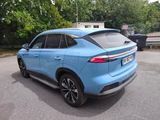 the rear end of a blue car parked in a parking lot