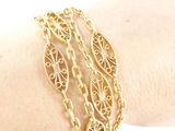 gold plated bracelet with filigree design on a woman ' s arm
