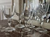 several empty wine glasses sitting on top of a counter next to a mirror