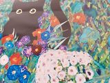 a picture of a black cat in a field of flowers
