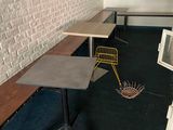 a table and a chair in a room with a brick wall