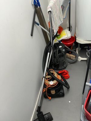 une photo d'une pièce avec un aspirateur et d'autres produits d'entretien