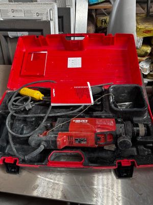 une boîte à outils rouge contenant des outils, posée sur une table