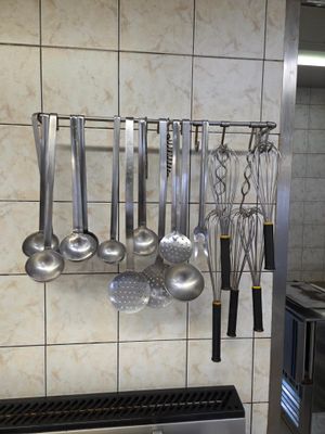 une photo d'une cuisine avec tout un tas d'ustensiles accrochés au mur