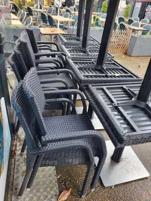 many chairs and tables that are outside on the sidewalk