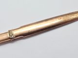a close up of a bullet on a table with a white background