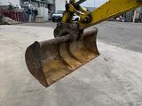 the back end of a yellow bulldozer sitting in a parking lot