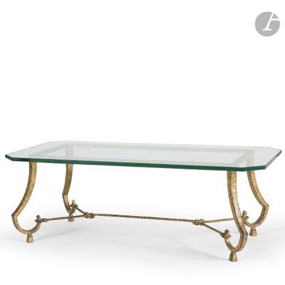 une table basse en verre avec des pieds en métal doré et un plateau en verre