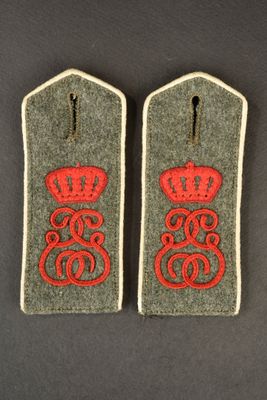 two military badges with red thread and a crown on them