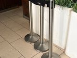 three metal poles that are standing in front of a planter