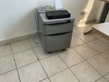 a printer sitting on top of a small gray cabinet