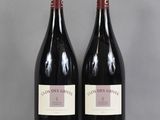 two bottles of red wine sitting on top of a table