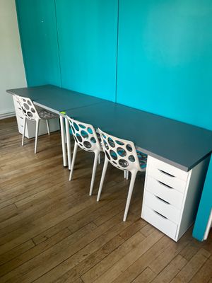 trois chaises et un bureau dans une pièce aux murs bleus