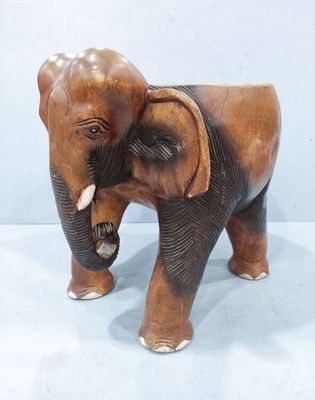statue d'un éléphant avec ses défenses, posée sur une surface blanche