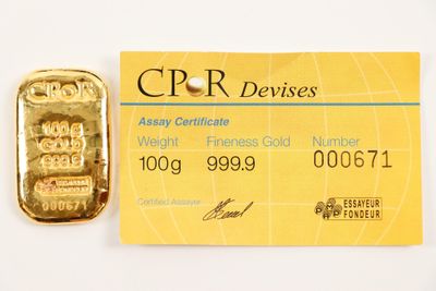 credit card with a gold bar next to it on a white surface