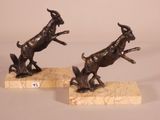 pair of bronze statues of a goat and a dog on marble bases