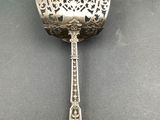 a silver spoon with a handle on a table next to a book