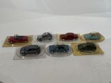 six small toy cars in plastic bags on a table