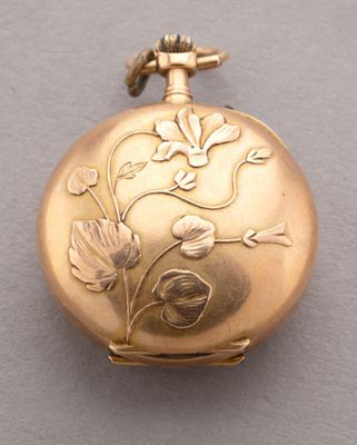 une image représentant une montre de poche en or ornée de fleurs