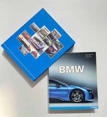 deux livres posés sur une table blanche, sur laquelle se trouve une boîte bleue