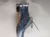 pair of blue leather shoes with laces on them on a white surface