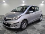 La Toyota Yaris argentée est garée sur un sol en carrelage à damier.