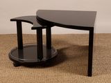 table basse en verre noir avec deux pieds courbés et une tablette en verre