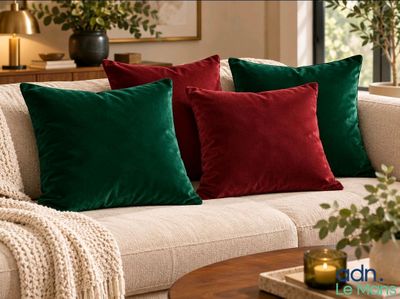 three green and red pillows on a white couch in a living room