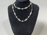 Ensemble collier et bracelet en argent présenté sur un mannequin d'exposition