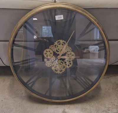 une horloge posée par terre devant un canapé