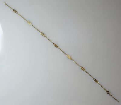 a close up of a gold bracelet on a white surface
