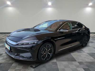 a black car is parked on a checkered floor in a garage