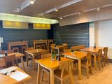tables and chairs are lined up in a restaurant with wood flooring