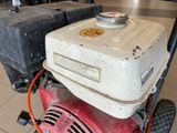 a red and white gas powered lawn mower on the ground