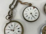 several different types of pocket watches are displayed on a white surface