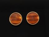 a pair of orange glass earrings on a black surface