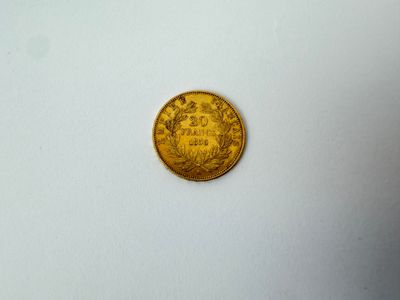 gros plan d'une pièce d'or sur une surface blanche