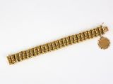 a close up of a gold chain bracelet on a white surface